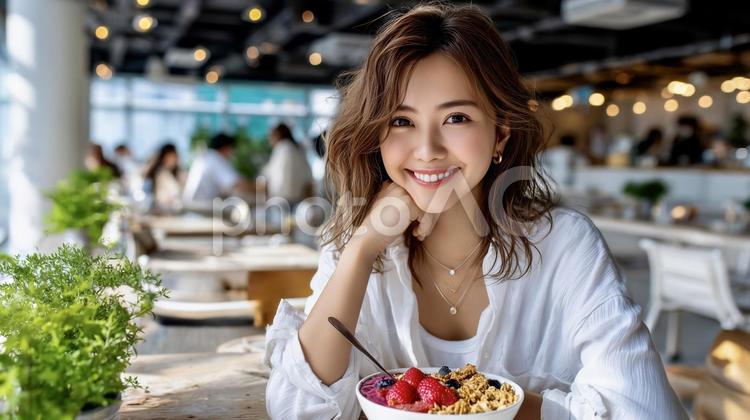アサイーボウルを食べる笑顔の若い女性 アサイーボウル,女性,朝食の写真素材
