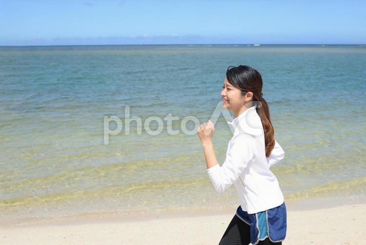 海辺でジョギングをする女性 女性,運動,健康の写真素材