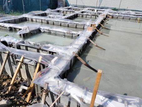 雨水が溜まった建築中の住宅の基礎工事現場の写真