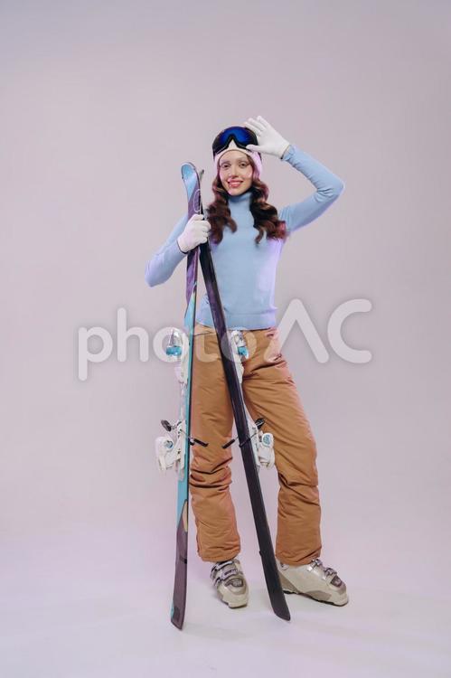 スキー板を持つ女性の全身 冬,スポーツ,ウィンタースポーツの写真素材