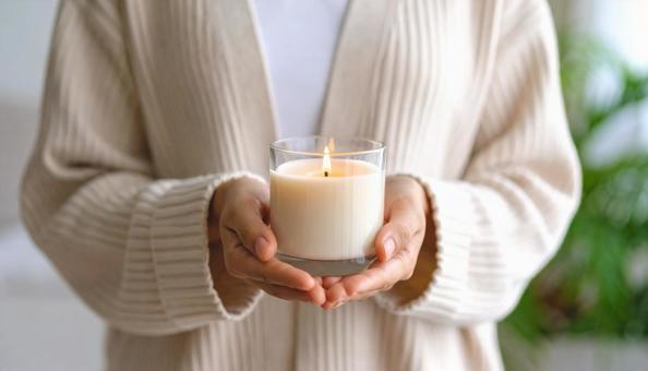 アロマキャンドルを持つ女性の手もとの写真
