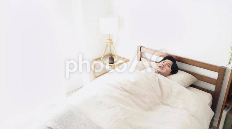 ベッドの中で寒気を感じる男性 男性,寒気,冷えの写真素材
