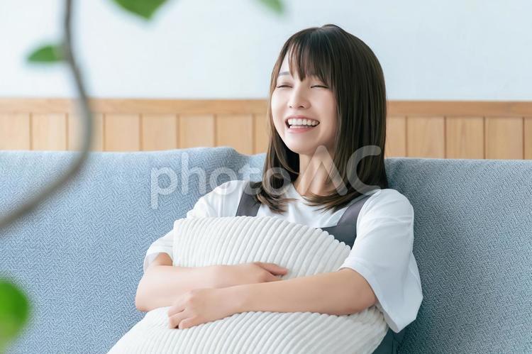 リビングのソファに座る笑顔の女性 女性,ソファ,笑顔の写真素材