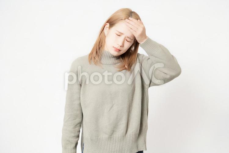 体調が悪くて頭に手を当てる若い女性 頭痛,頭,若いの写真素材