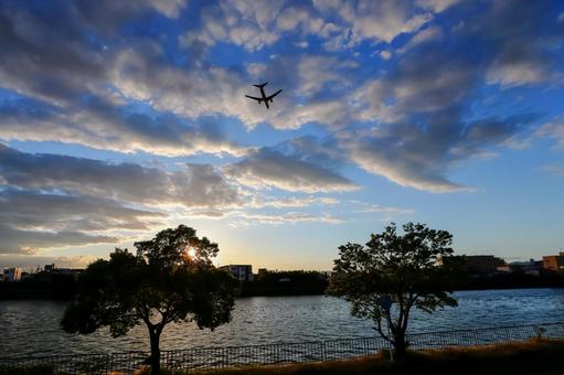 夕焼けと飛行機のシルエット 飛行機,シルエット,夕焼けの写真素材