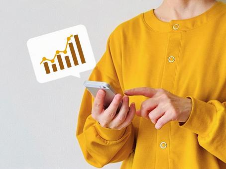 スマホを操作する女性（上向きグラフ） スマホ,女性,グラフの写真素材