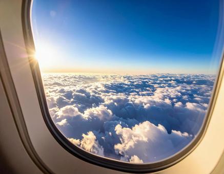 飛行機の窓から見える雲海と夕日 飛行機の窓から見える雲海と夕日の写真