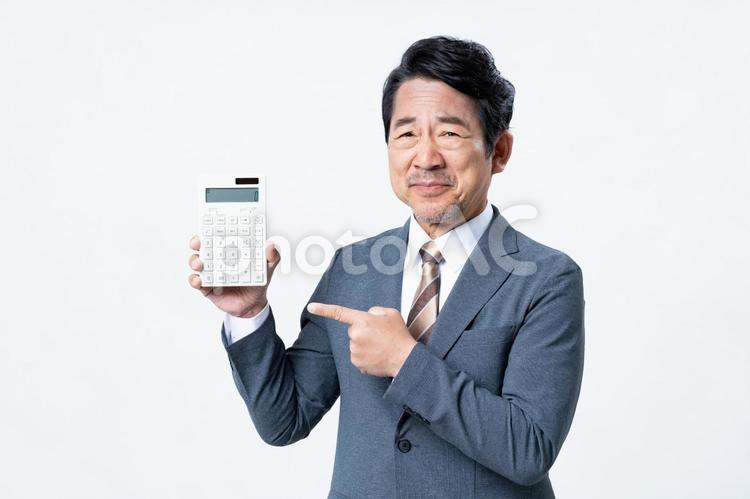 電卓を持って悩むミドルのビジネスマン 電卓,ビジネスマン,ミドルの写真素材