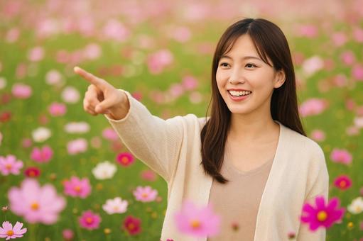 コスモスを指差す女性 コスモスを指差す女性の写真