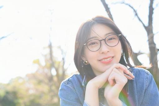カメラ目線で微笑むメガネの女性 カメラ目線で微笑むメガネの女性の写真