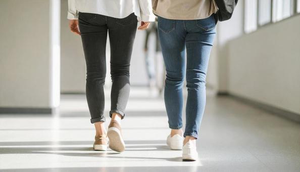 大学のキャンバスを並んで歩く二人の大学生 大学のキャンバスを並んで歩く二人の大学生の写真