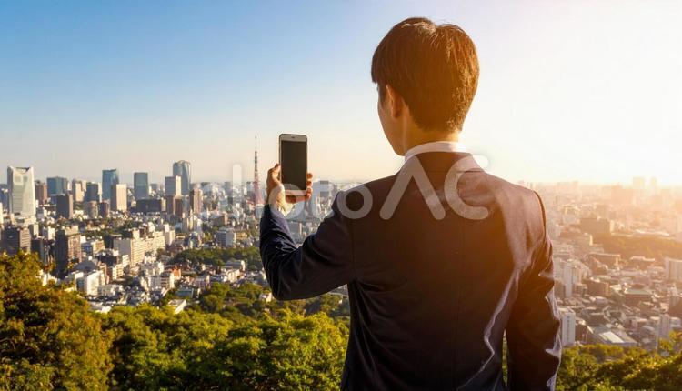 都市背景に携帯画面を見ているビジネスマン 都市,高層ビル,起業家の写真素材