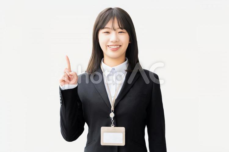 人差し指を立てて案内する笑顔の女性 女性,ビジネス,笑顔の写真素材