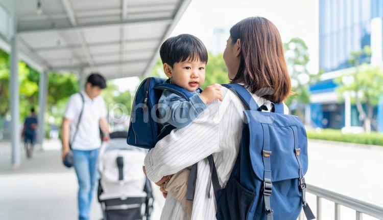 子供の送り迎えをする母親 抱っこ,幼稚園,出勤の写真素材