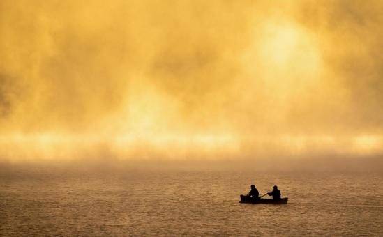 黄金色の朝霧の中、静かに漕ぎ進む小さな舟 然別湖,湖,朝霧の写真素材