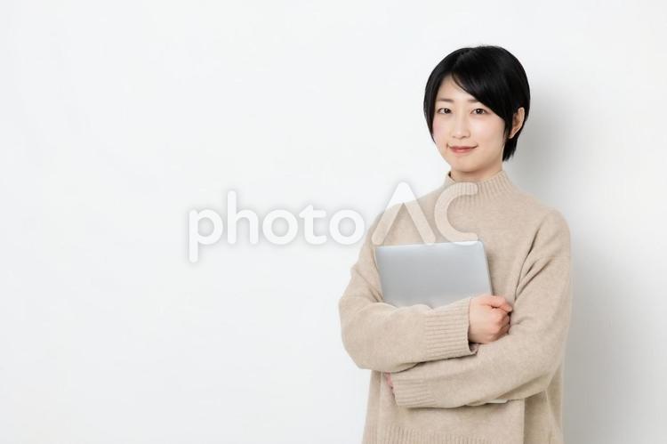 パソコンを抱えている笑顔の女性（コピースペース） 女性,女子,女の写真素材