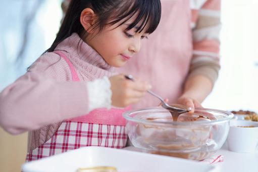 スイーツ作りに夢中な女の子のクッキングシーン 女の子,チョコレート,スプーンの写真素材