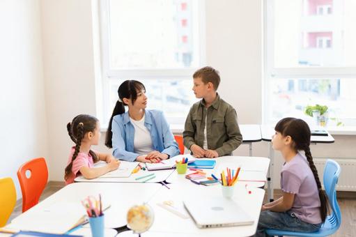 生徒と見つめる先生 女性,女の子,男の子の写真素材