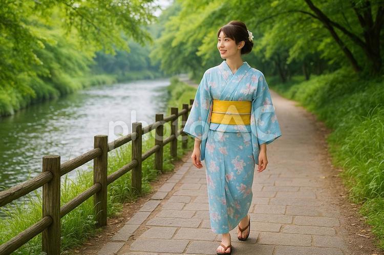 浴衣姿で川沿いの小道を歩く女性（初夏） 浴衣,女性,日本人の写真素材