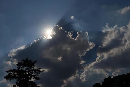 青空と灰色雲から白く光り輝く太陽の出る空 青空,灰色雲,白くの写真素材