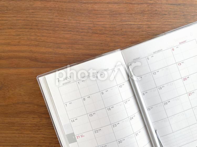 机に開いて置いた7月のスケジュール帳 スケジュール帳,予定,手帳の写真素材