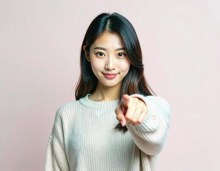 正面を指差す女性 正面を指差す女性の写真