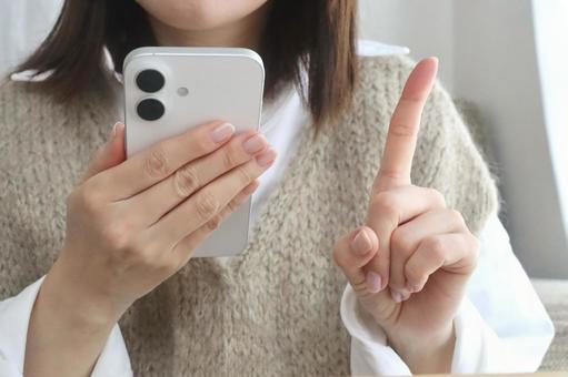 スマホを持つ女性　人差し指ポーズ スマホ,女性,1の写真素材