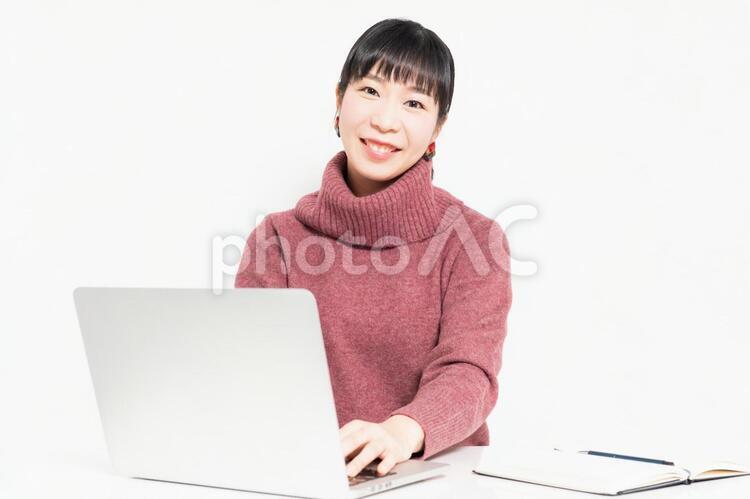 笑顔でノートパソコンを使う女性 女性,ビジネス,パソコンの写真素材