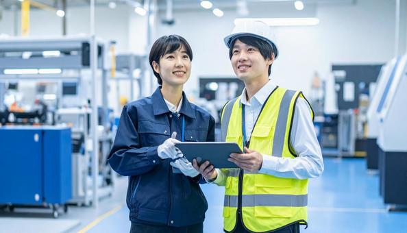 工場でタブレットで製品を検査する作業員 工場でタブレットで製品を検査する作業員の写真