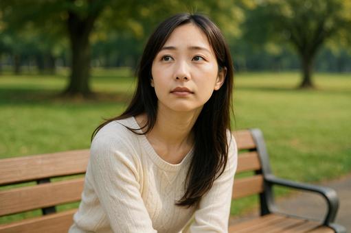 公園で物思いにふける女性 公園で物思いにふける女性の写真
