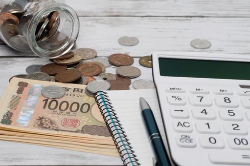 電卓と一万円札と瓶からこぼれた小銭 電卓と一万円札と瓶からこぼれた小銭 お金,貯金,貯蓄の写真素材