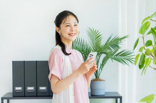 スマホを操作する女性 ビジネスウーマン,笑顔,スマホの写真素材