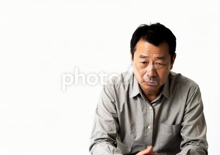 うつむいて悩む中年男性（白背景）02 男性,中年,うつむくの写真素材
