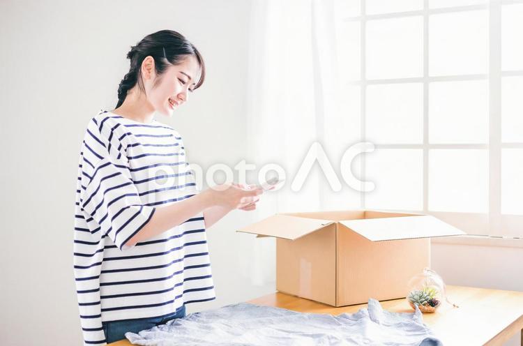 古着をフリマアプリに出品する女性 フリマ,出品,古着の写真素材