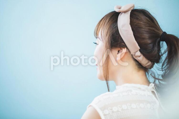 ヘアバンドをつけた女性 後頭部,ポニーテール,おしゃれの写真素材