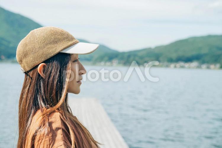 湖の桟橋に立つ女性キャンパーの横顔 キャンプ,湖,女性の写真素材