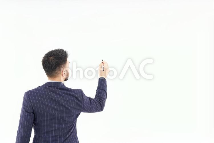 ペンで書くポーズをするスーツ姿の男性 ビジネスマン,スーツ,男性の写真素材