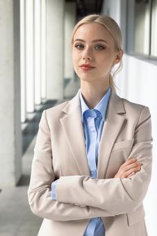 オフィスの通路で腕組みをするカメラ目線のビジネスウーマン ビジネスウーマン,ビジネス,女性の写真素材