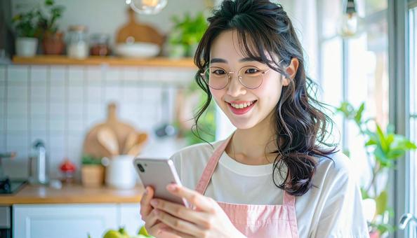スマホでポイ活する笑顔の女性 スマホでポイ活する笑顔の女性の写真