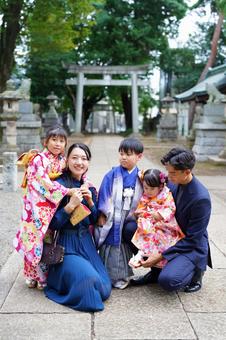 着物姿の子どもたちと記念撮影をする家族 着物姿の子どもたちと記念撮影をする家族 七五三,お参り,七五三参りの写真素材