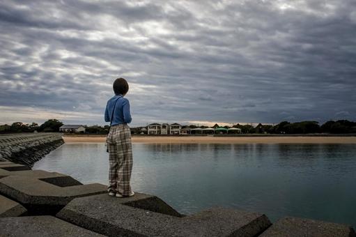 ＜素材＞秋の海辺を散策する女性の後ろ姿 女性,悩む,海の写真素材