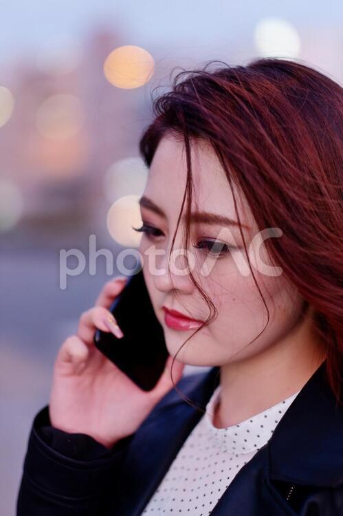 夕方の街なかでスマホを使う派手目なメークをした日本人女性2 女性,日本人,アジア人の写真素材
