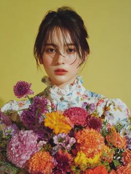 カラフルな花と黄色い背景におしゃれな女性の写真