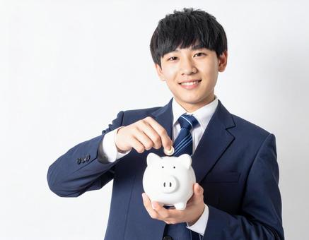 ブタの貯金箱をもつ男の子・男子生徒 ブタの貯金箱をもつ男の子・男子生徒の写真