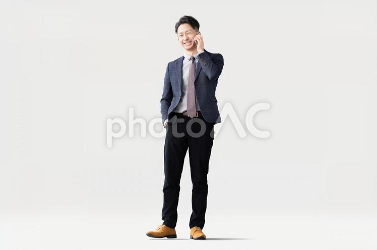 スマホで通話をする笑顔の男性ビジネスマン 男性,スマホ,ビジネスの写真素材