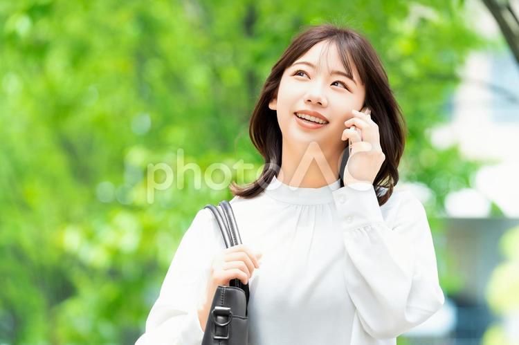 スマホで話す笑顔の女性・ビジネスウーマン 女性,スマホ,夏の写真素材