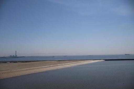 埋立地の海岸と海と船と工場地帯と青空 埋立地の海岸と海と船と工場地帯と青空の写真