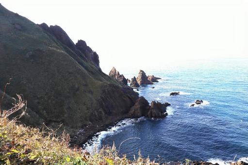 佐渡島北部、大野亀海岸 岩山,海,白波の写真素材