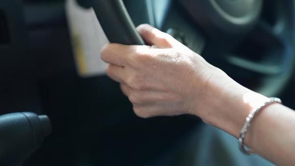 車のハンドルを握る女性の手 ハンドル,運転,女性の写真素材