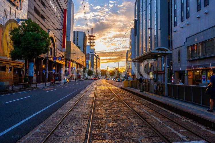夕暮れの空と伊予鉄道の線路と都市風景 伊予鉄道,道路,線路の写真素材